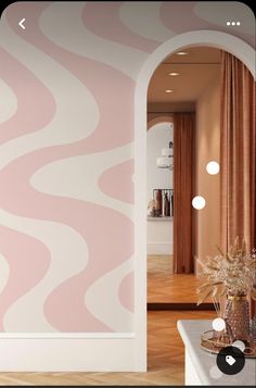 a pink and white wall with an arch leading into the living room that is decorated in modern style