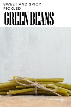 green beans tied up with twine on top of a wooden table and text overlay that reads sweet and spicy pickled and spicy green beans