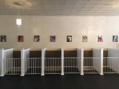 a room with white railings and pictures hanging on the wall behind them, along with black carpeting