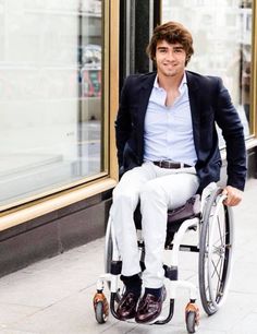 a man sitting in a wheel chair on the sidewalk