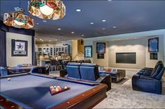 a pool table sitting in the middle of a living room filled with couches and chairs