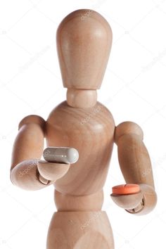 a wooden mannequin holding an electronic device in his hand and pointing at it