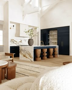 a large kitchen with marble counter tops and wooden stools in the middle of it