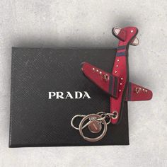 Prada Saffiano Airplane Bag Charm/Keychain Approx Measurements: 4.5 X 5 X 1” (Without Key Ring) Airplane Made With Saffiano Leather In Red Details In Saffiano Leather In Navy Blue Silver Hardware Lobster Clasp, Key Ring, & Logo Engraved Charm Preowned: Only Used A Few Times Great Condition No Major Flaws Or Damages Please See Photos Comes With Original Box & Card Made In Italy Authenticity Guaranteed Purchased At Prada Milan Airplane Bag, Ring Logo, Red Details, Prada Accessories, Prada Saffiano, Charm Keychain, Box Card, Card Box, Silver Hardware