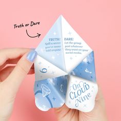 a hand holding an origami fortune teller with the words truth or dare written on it