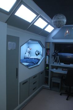 a room with a bed, desk and shelves on the wall is lit up by bright lights