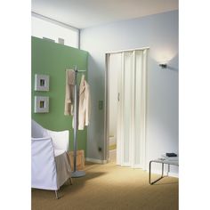 a bedroom with a green wall and white closets in the corner next to a bed