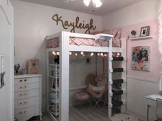 a white loft bed sitting in a bedroom next to a desk and chair with lights on it