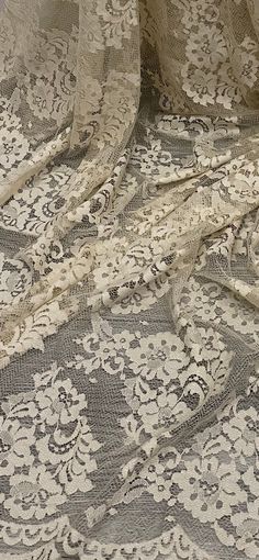 an old lace fabric with white flowers on it