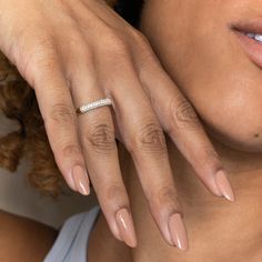 a close up of a woman's hand with a diamond ring on her finger