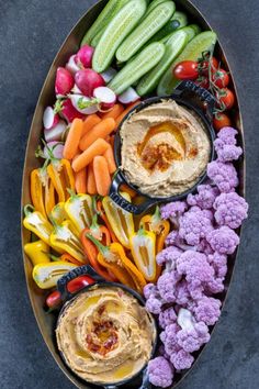 a platter filled with carrots, cauliflower and other vegetables