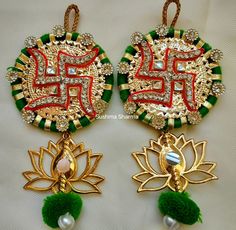 two pieces of jewelry with green, red and white designs on them sitting next to each other