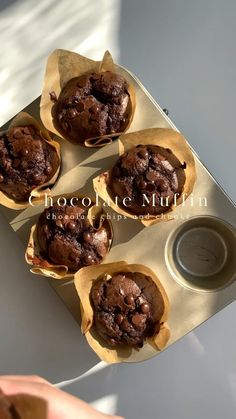 four chocolate muffins sitting on top of a pan