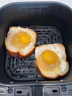 two pieces of bread with an egg in them sitting on top of a toaster