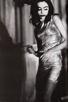 a black and white photo of a woman in a shiny dress with her eyes closed