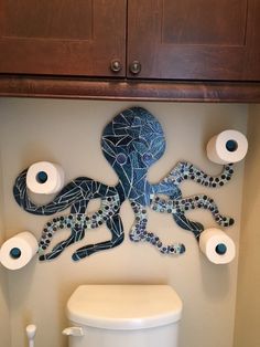 a bathroom with toilet paper and octopus artwork on the wall