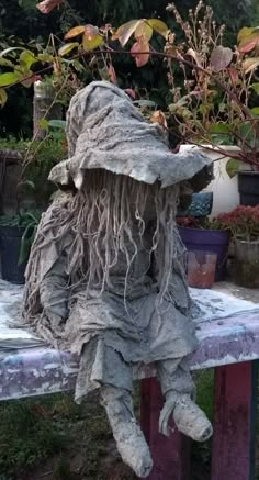 a stuffed animal sitting on top of a wooden bench next to potted planters