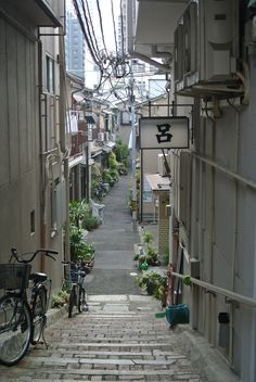 a narrow alleyway with bikes parked on the side and buildings in the back ground