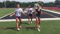 three girls are playing with a frisbee on the field