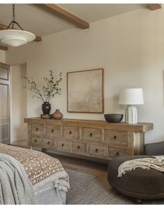 a bedroom with a bed, dresser and chair in it's centerpieces