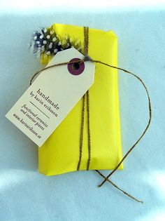 a yellow wrapped gift with a tag attached to it