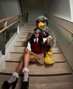 a woman sitting on some stairs with a stuffed bird