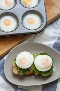 two eggs are sitting on top of toast in a muffin tin next to an egg tray