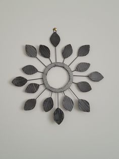 a circular metal clock with leaves on it