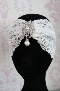 a white headband with pearls and lace on top of a mannequin's head