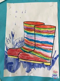 a child's drawing of a pair of colorful rain boots on a piece of paper