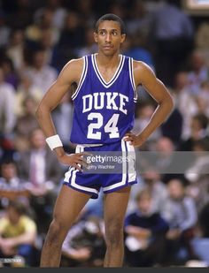 a basketball player standing on the court with his hands on his hips and looking at the camera