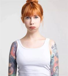 a woman with red hair and tattoos on her arms, wearing a white tank top