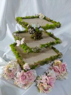 three tiered cake decorated with moss and flowers