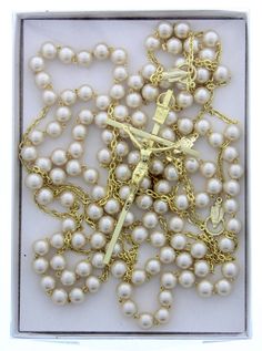 a box with some pearls and a cross on it