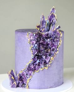 a cake with purple icing and gold decorations