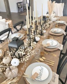 a table set for thanksgiving dinner with candles and place settings