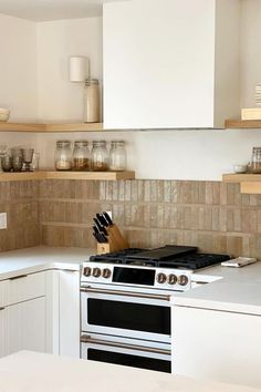 A kitchen with white walls and a modern white hood features a backsplash of tan zellige tile. Zia Tile, Boho Bungalow, Neutral Tile, Zellige Tile, Design Remodel, Moroccan Tile, Shades Of Beige, Super Chunky, Super Natural