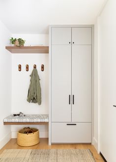 a coat rack and bench in a white entryway