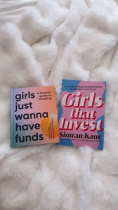 two books sitting on top of a white bed next to each other in front of a fluffy blanket