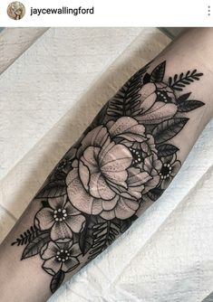 a black and white flower tattoo on the arm