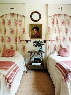 two twin beds in a bedroom with pink and white bedding, one has a painting on the wall