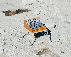 an orange and white game table sitting in the middle of some rocks