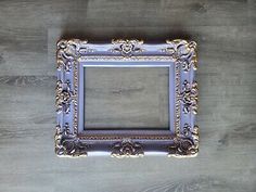 an ornate blue and gold frame on a wooden surface