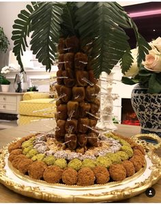 a palm tree made out of donuts on a plate with flowers in the background