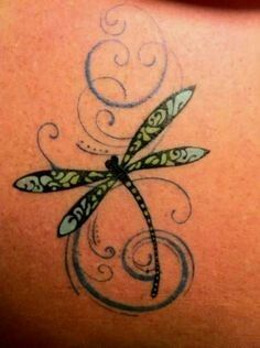 a woman's back with a dragonfly tattoo on it