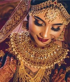 a woman wearing gold jewelry and makeup