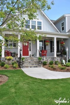 a house with landscaping in front of it and red door on the side of the house