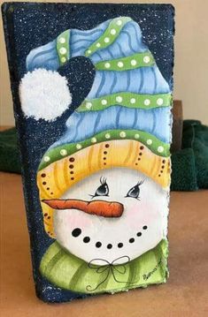 a painting of a snowman with a hat and scarf on it's head