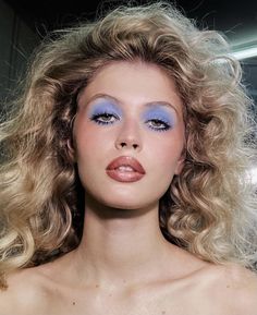 a woman with blonde hair and blue eyeshadow