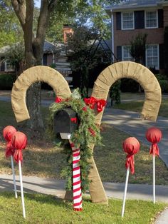 some red and white candy canes in front of a mailbox decorated for christmas